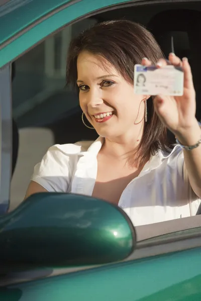 Счастливая женщина показывает водительские права — стоковое фото
