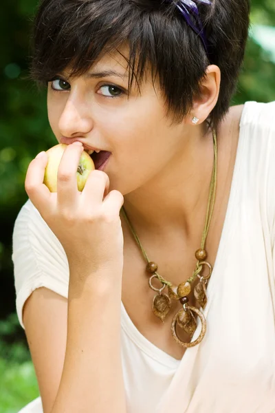 Симпатичная девушка ест яблоко — стоковое фото
