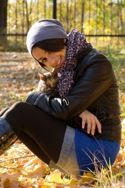 çekici esmer kız ve sıcak sonbahar günü parkta de kedi