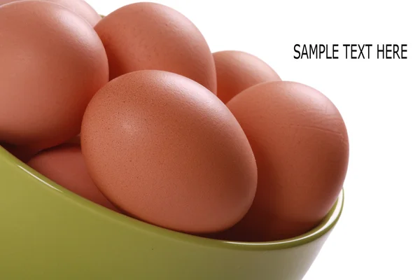 Färska bruna ägg i grön skål. isolerade över vita — Stockfoto