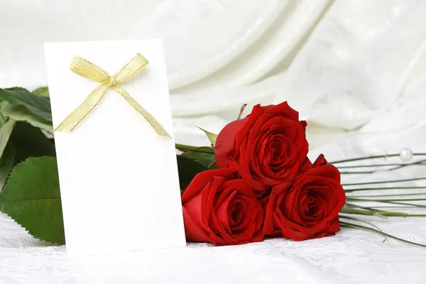 Schöne rote Rosen und Einladungskarte — Stockfoto
