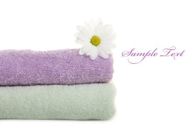 Stacked colorful towels with white flower. Isolated over white clipart