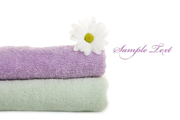 stock image Stacked colorful towels with white flower. Isolated over white