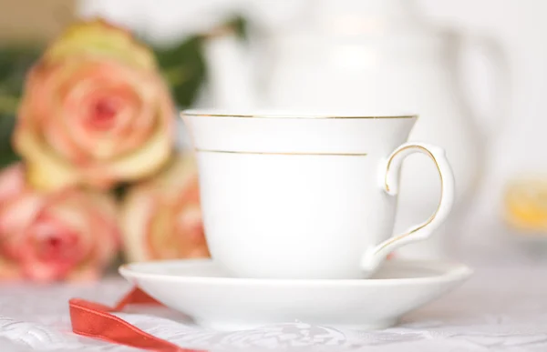 玫瑰对桌上的茶杯 — 图库照片