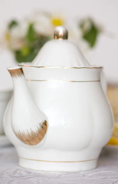 反对用鲜花花瓶桌上的茶壶 — 图库照片