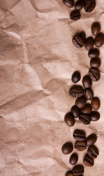Kaffeebohnen auf einem zerknüllten Papier Textur Hintergrund — Stockfoto