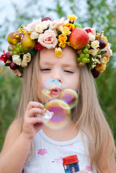 Little Girl Wreath Flowers Blows Soap Bubbles — Stock Photo, Image