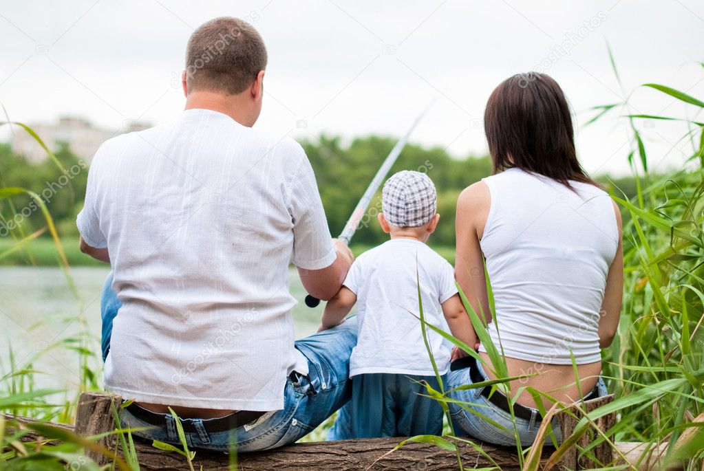 Family fishes on the riverside