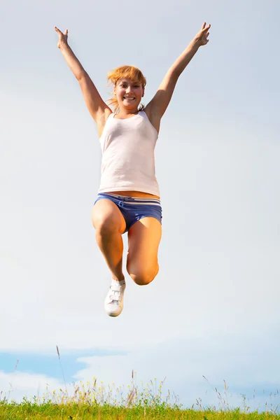 日当たりの良い牧草地で跳んで幸せな少女 — ストック写真