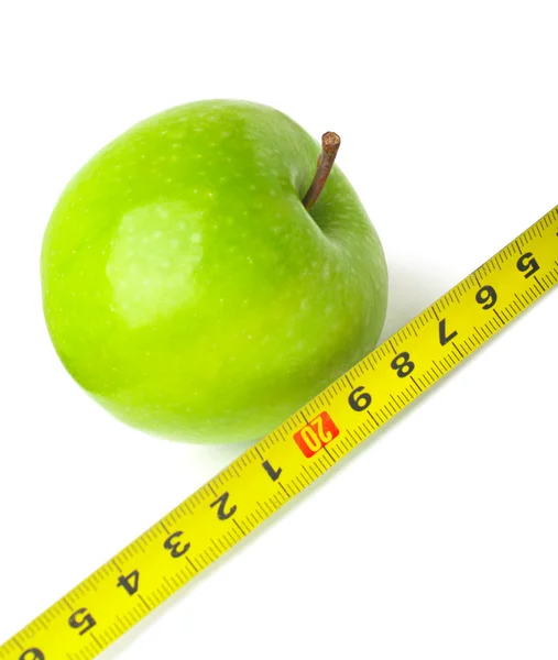 stock image Conceptual composition. Green apple with a measuring instrument. Picture on the subject of careful selection of food and control your weight.