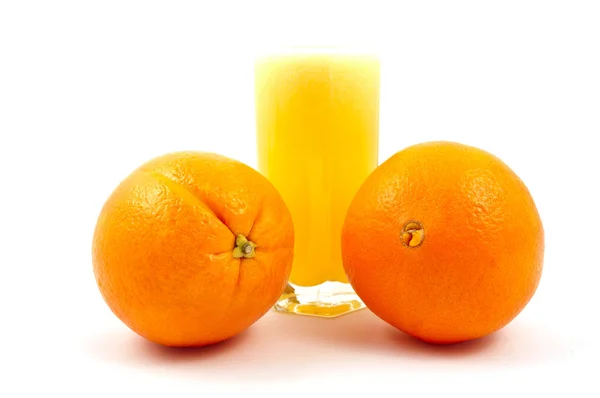 Tasse frisch gepresster Orangensaft und Orangen — Stockfoto