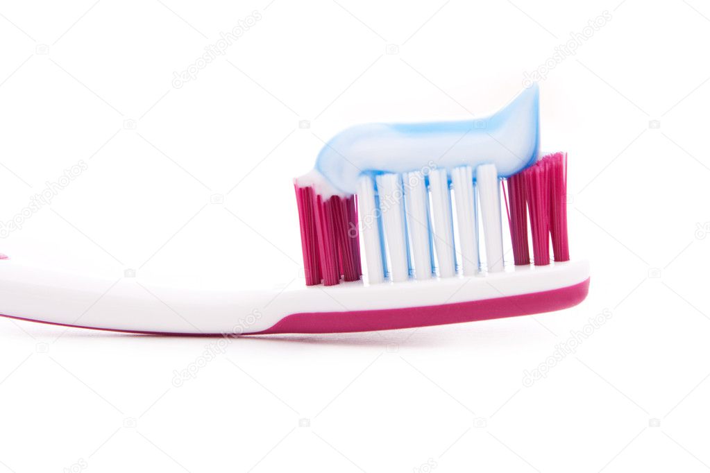 Red toothbrush with toothpaste isolated on white