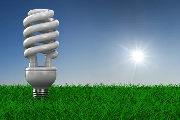 Энергосберегающая лампочка на траве. 3D изображение — стоковое фото