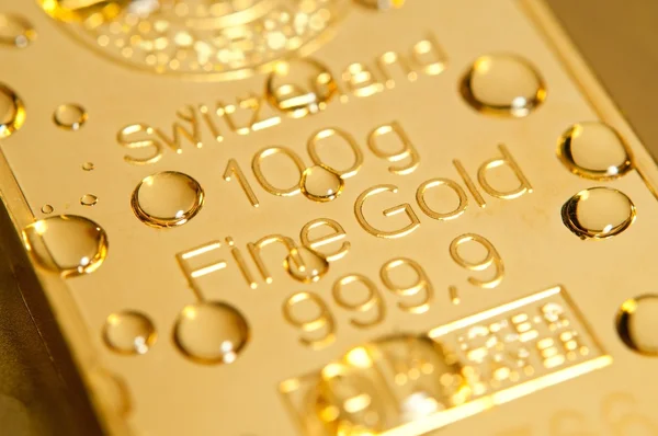 Drops on a gold ingot — Stock Photo, Image