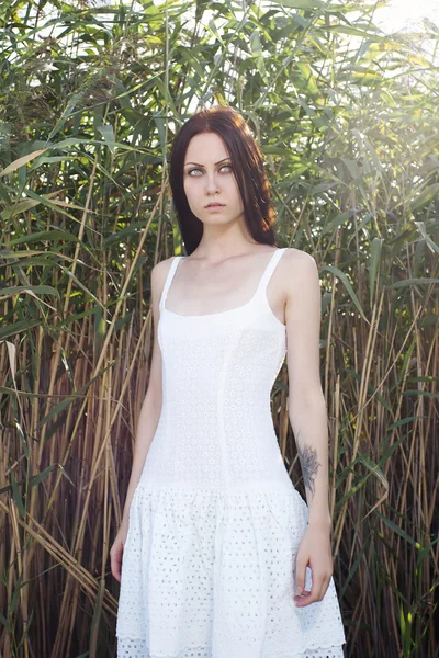 Vacker kvinna i en vit klänning — Stockfoto