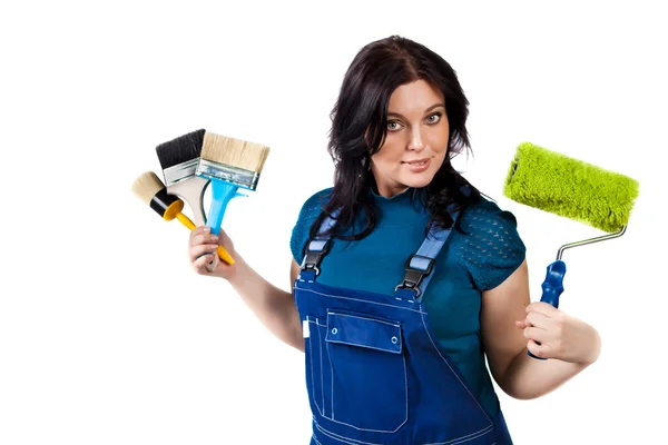 Pretty woman in coveralls with paintbrushes and roller — Stock Photo, Image