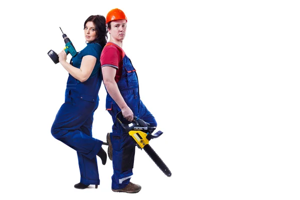 Man and woman with the chainsaw and drill are standing back to b — Stock Photo, Image