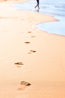 Footprints on yellow sand clipart