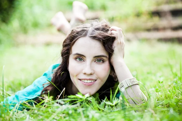 Leží na trávě docela usmívající se dívka — Stock fotografie