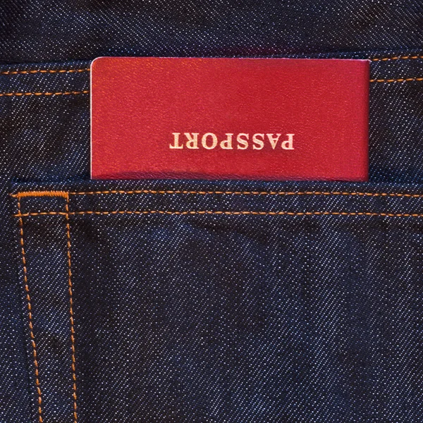 Bolsillo vaquero azul oscuro con pasaporte rojo — Foto de Stock