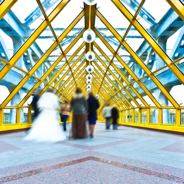 Silhouettes in motion blur in yellow passage — Stock Photo, Image