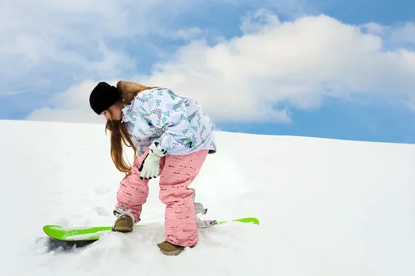 Молодая девушка рядом сноуборд крепления — стоковое фото