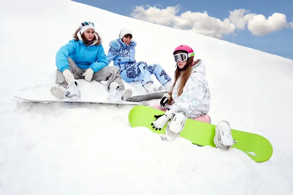 Три молодые девушки сидят на снегу — стоковое фото