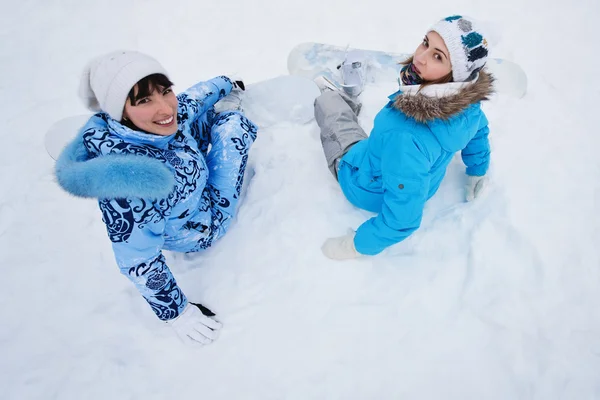 Zwei Mädchen sitzen auf Schnee und bereiten sich auf die Fahrt vor — Stockfoto