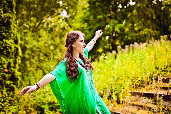 Этническая девушка в зеленом с длинными каштановыми волосами — стоковое фото