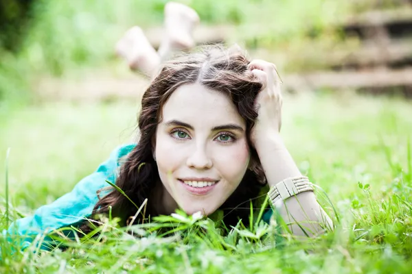 Liggend op gras vrij glimlachend meisje Rechtenvrije Stockfoto's
