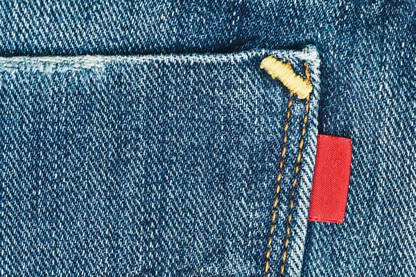 Blaue alte Jeanstasche mit leerem roten Etikett — Stockfoto