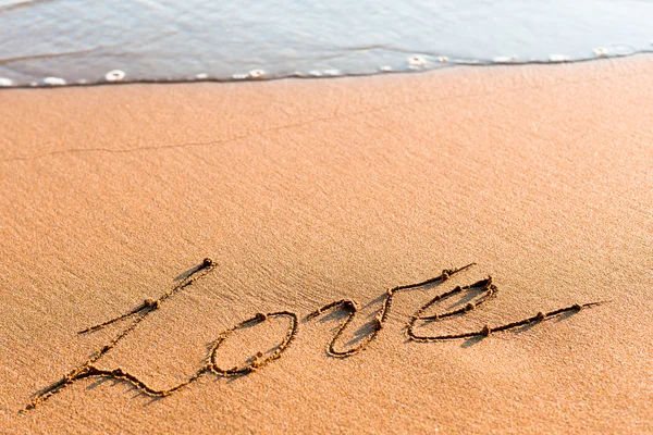 Woord liefde op zand Stockfoto