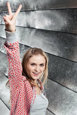 Portrait of young smiling girl showing gesture V-Victory! clipart