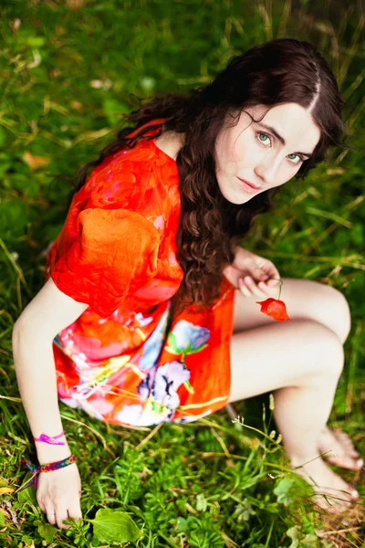 잔디에 드레스 좌석에 여자에 — 스톡 사진