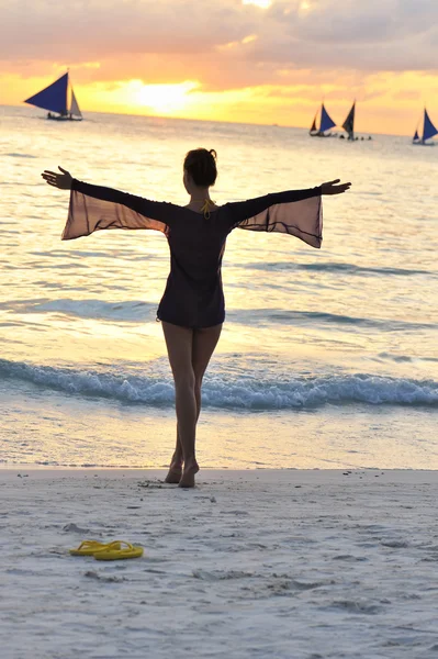 Девушка на пляже на закате — стоковое фото