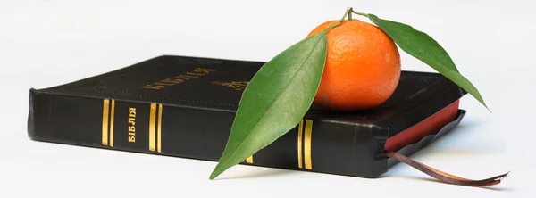 Библия с мандарином — стоковое фото