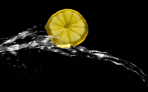 黒い背景に水のしぶきのレモン — ストック写真