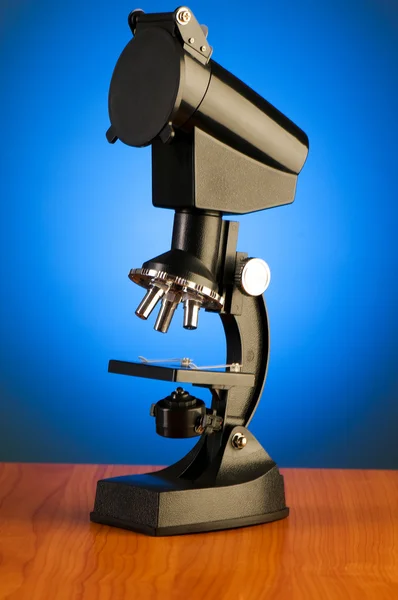 Microscopio contra fondo azul degradado — Foto de Stock