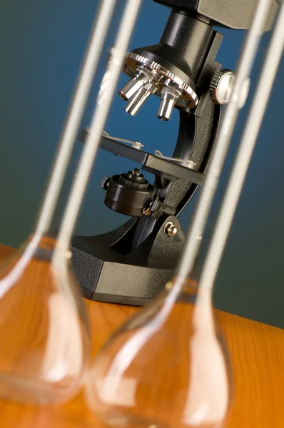 Mikroskop proti modré gradientní pozadí — Stock fotografie