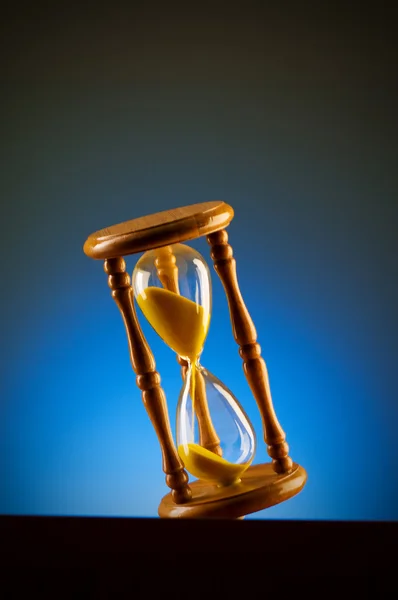 Time concept with hourglass against background — Stock Photo, Image