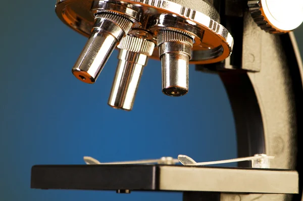 Микроскоп на фоне синего градиента — стоковое фото