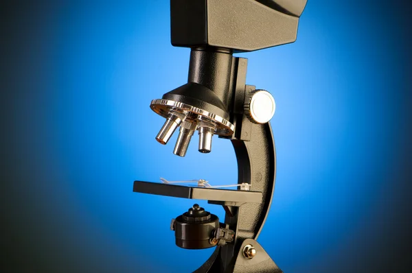 Microscópio contra fundo gradiente azul — Fotografia de Stock