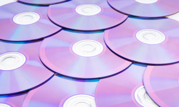 Viele DVDs auf weißem Hintergrund angeordnet — Stockfoto