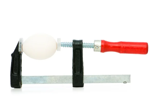 Strength concept with egg and clamp on white — Stock Photo, Image