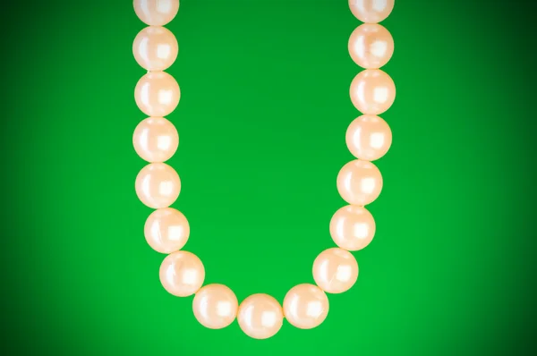 Perlenkette vor buntem Hintergrund — Stockfoto