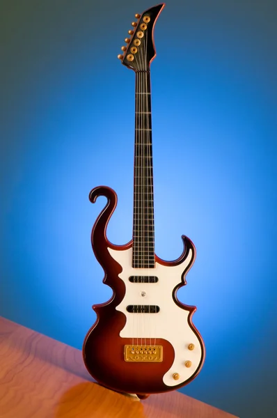 Деревянная гитара на градиентном фоне — стоковое фото