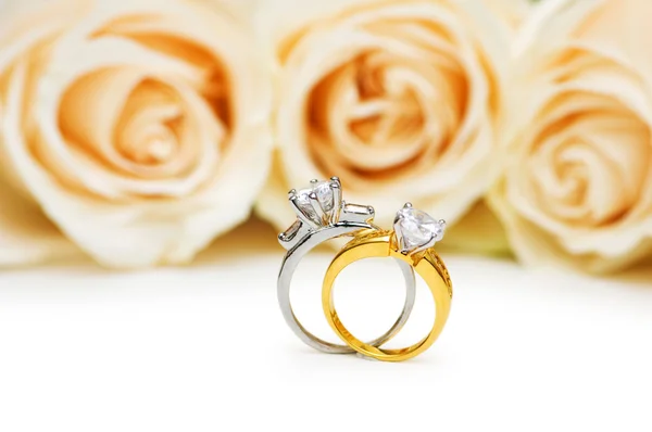 Rosas e anel de casamento isolado no branco Fotografia De Stock
