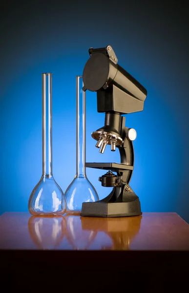 Микроскоп на фоне синего градиента — стоковое фото