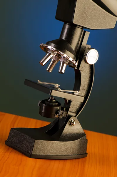 Microscopio contra fondo azul degradado —  Fotos de Stock