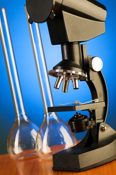 Mikroskop proti modré gradientní pozadí — Stock fotografie
